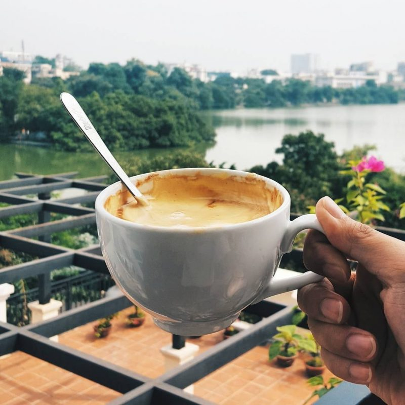 Holding a cup of coffee from a small café near Hoan Kiem Lake